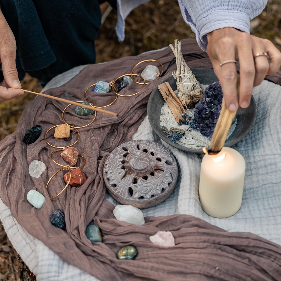 Ritual-Arrangement mit Kristallen, Kerze und Palo Santo – Sinnbild für die energetische Arbeit